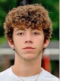 headshot of a young man with curly hair